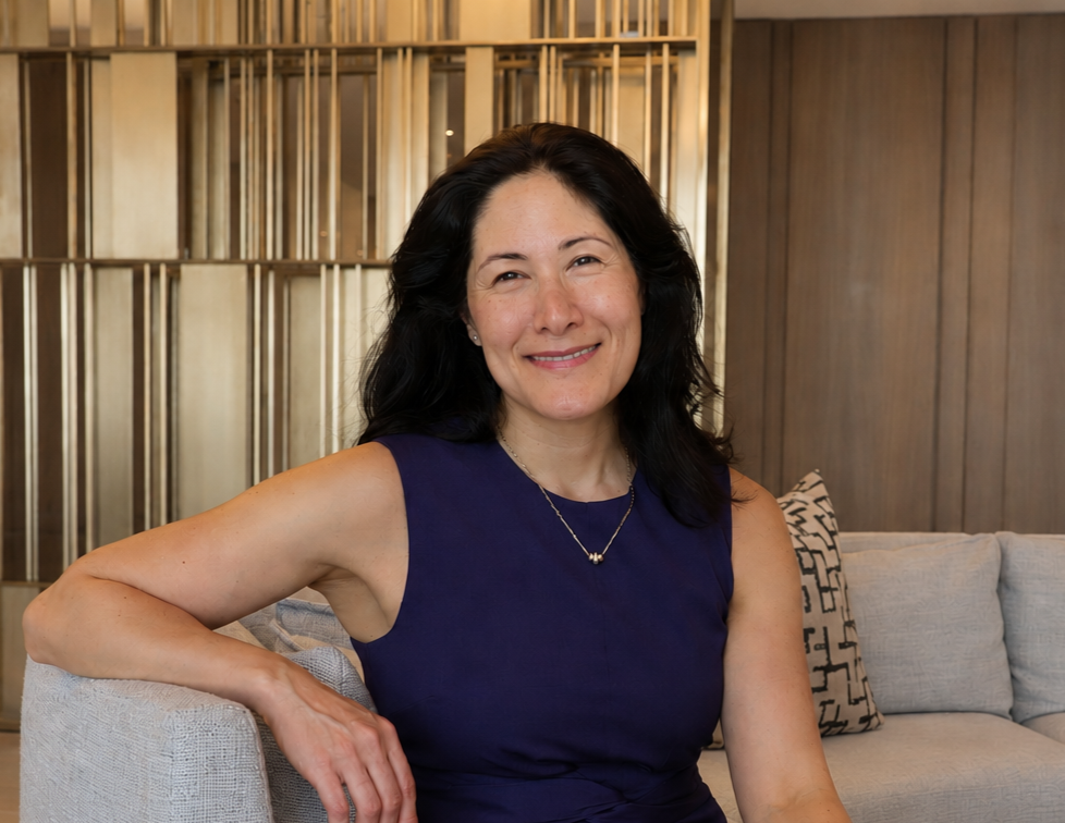 Dr. Alexandra Channing seated on a navy sofa in a modern clinical office.